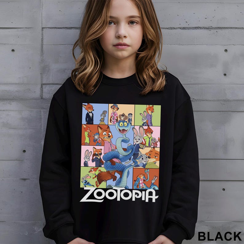May include: Black sweatshirt featuring a colorful graphic from the movie Zootopia. The graphic includes various characters in a grid pattern, with the word "Zootopia" in white text at the bottom. The word "BLACK" is printed in the bottom right corner.