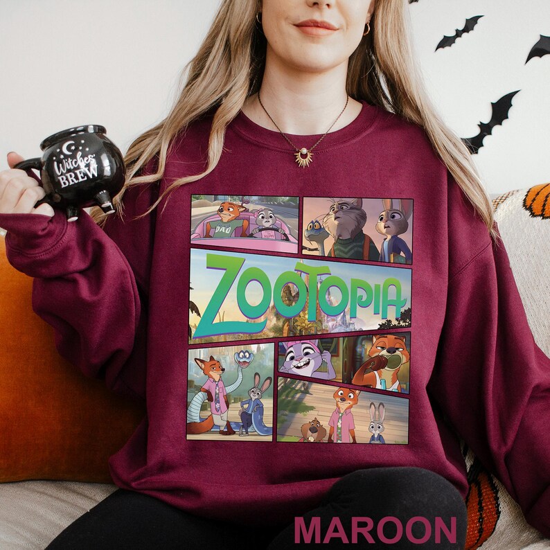 May include: Maroon sweatshirt featuring a comic strip design with characters and the title "Zootopia". The sweatshirt has a crew neck and long sleeves. The word "MAROON" is printed at the bottom of the sweatshirt.