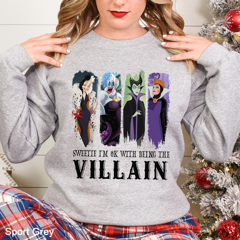 May include: Sport grey sweatshirt featuring four cartoon villain characters with the text "Sweetie I'm ok with being the Villain". The sweatshirt is a long-sleeved crew neck.