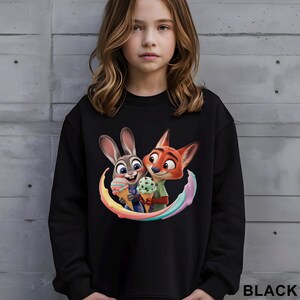 May include: Black sweatshirt featuring a colorful graphic of cartoon characters, a rabbit and a fox, holding ice cream cones. The word "BLACK" is printed in white at the bottom right.