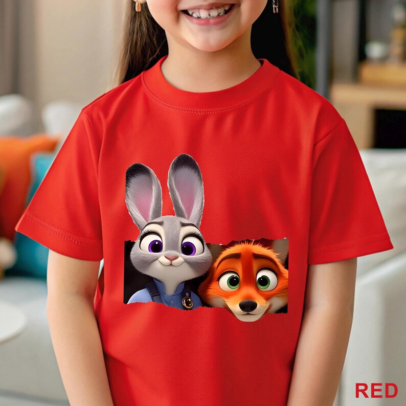 May include: A red t-shirt featuring a graphic of Judy Hopps and Nick Wilde from Zootopia. The cartoon characters are depicted with detailed facial features. The word "RED" is printed in the bottom right corner.