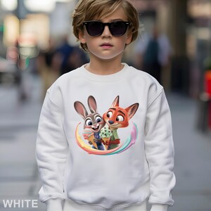 May include: White sweatshirt featuring a colorful graphic of Judy Hopps and Nick Wilde from Zootopia, holding ice cream cones. The word "WHITE" is printed at the bottom. The sweatshirt is made of a soft material.