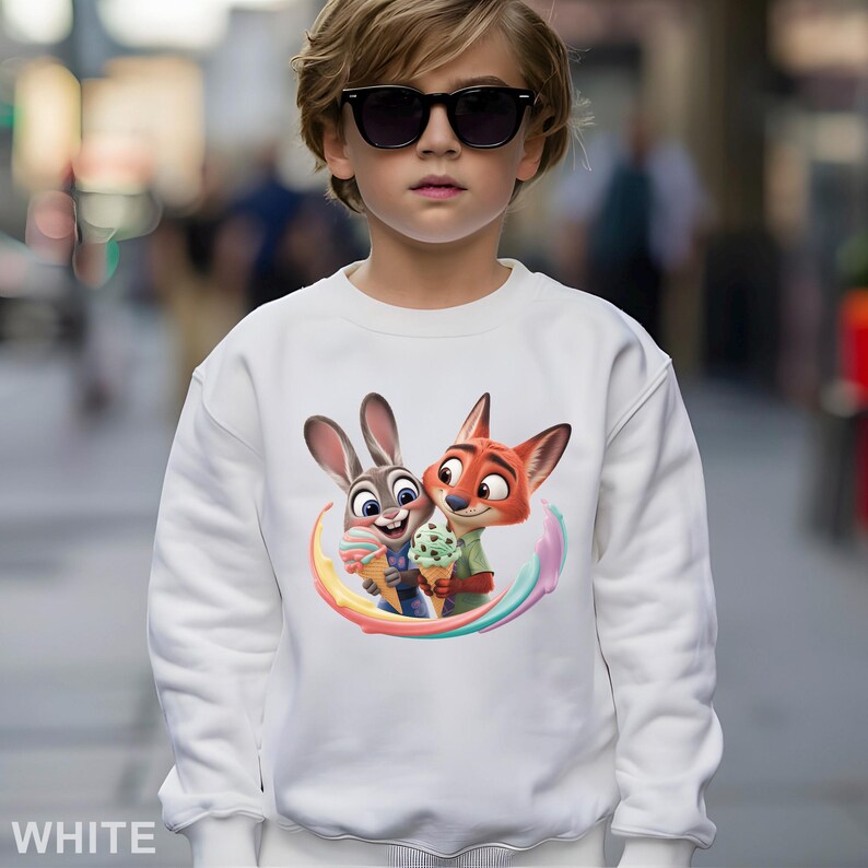 May include: White sweatshirt featuring a colorful graphic of Judy Hopps and Nick Wilde from Zootopia, holding ice cream cones. The word "WHITE" is printed at the bottom. The sweatshirt is made of a soft material.