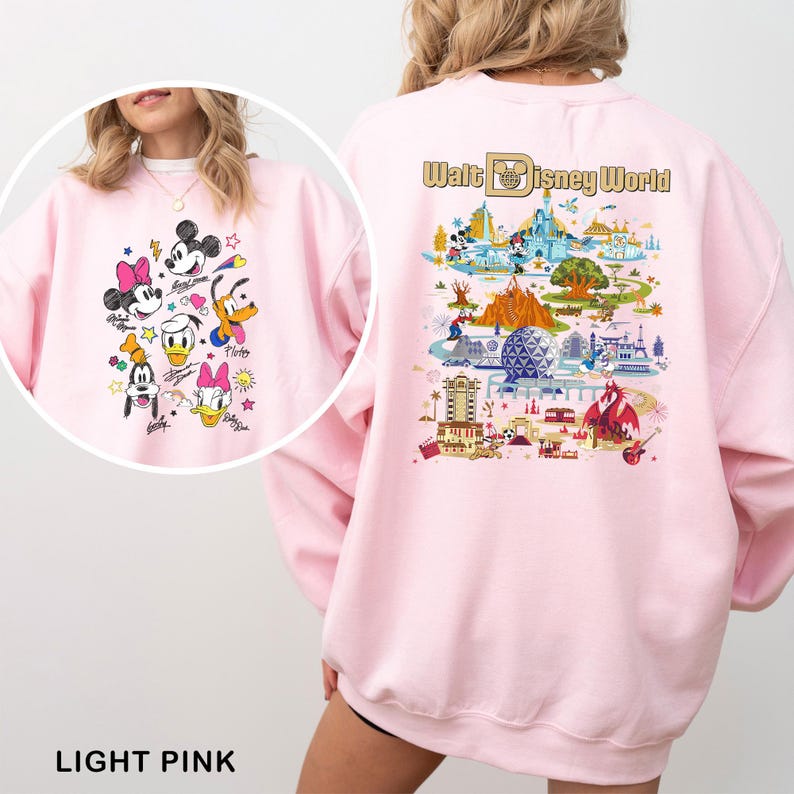 May include: Light pink sweatshirt featuring a colorful graphic of Disney characters on the front and a Walt Disney World map design on the back. The sweatshirt has long sleeves and a crew neck. The text "LIGHT PINK" is at the bottom.