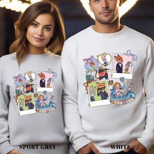 May include: Sport grey and white sweatshirts featuring a colorful cartoon collage of characters. The design includes framed images of a fox, bunny, and other animals. The word "Zootopia" is visible on the design.