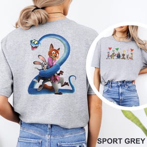 K&ouml;nnte beinhalten: Sportgraues T-Shirt mit einem farbenfrohen Grafikdesign von Zeichentrickfiguren. Das Design zeigt eine blaue Schlange, die sich um einen Fuchs und ein Kaninchen windet. Der Text "SPORT GREY" steht unten.