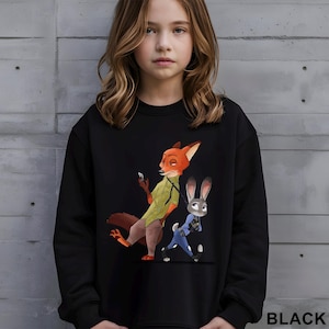 May include: Black sweatshirt featuring a cartoon illustration of Nick Wilde and Judy Hopps from Zootopia. Nick is a fox wearing a green shirt and Judy is a rabbit in a blue police uniform. The word "BLACK" is printed at the bottom.