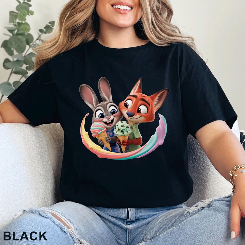May include: Black t-shirt featuring a colorful graphic of Judy Hopps and Nick Wilde from Zootopia holding ice cream cones. The design includes a rainbow arc and the word "BLACK" at the bottom.