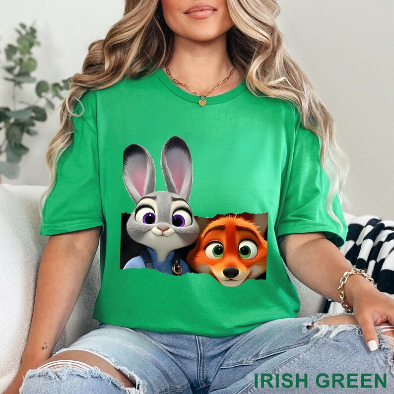 May include: Irish green t-shirt featuring a graphic of Judy Hopps and Nick Wilde from Zootopia. The cartoon characters are set against a black background. The text "IRISH GREEN" is printed at the bottom of the shirt.