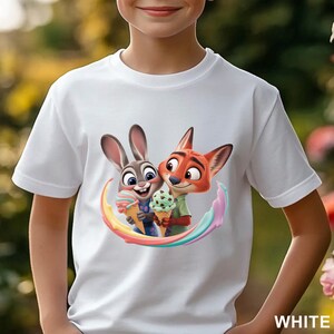 May include: White t-shirt featuring a colorful graphic of Judy Hopps and Nick Wilde from Zootopia holding ice cream cones. The design includes a rainbow arc and the word "WHITE" at the bottom right.