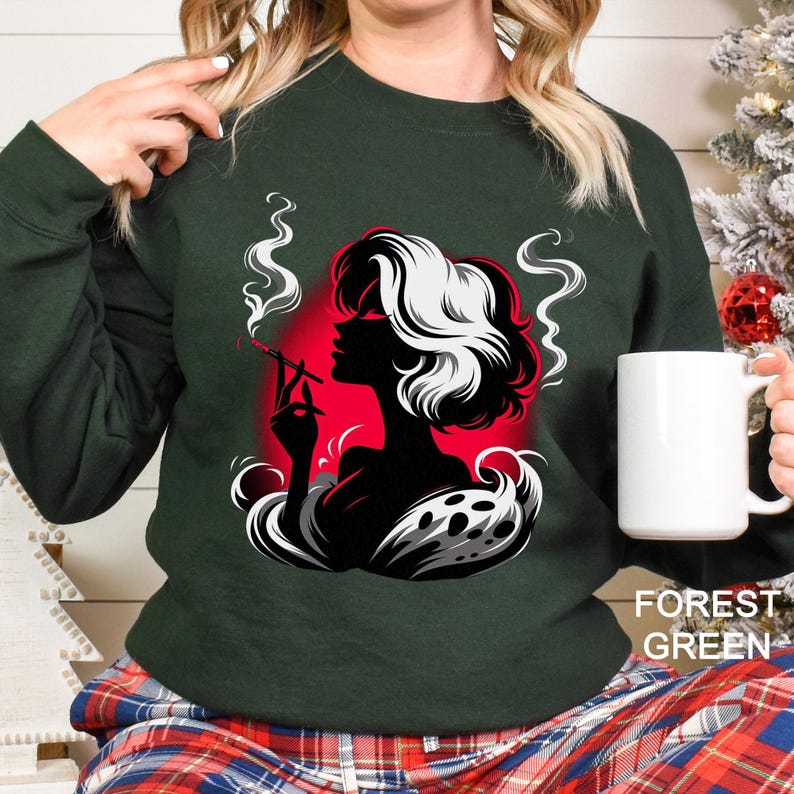 Op de afbeelding: Bostgroen sweatshirt met een zwart-wit silhouet van een rokende vrouw, tegen een rode achtergrond. Het ontwerp bevat gestileerde rook en de tekst "FOREST GREEN". Een witte mok wordt in de hand gehouden.