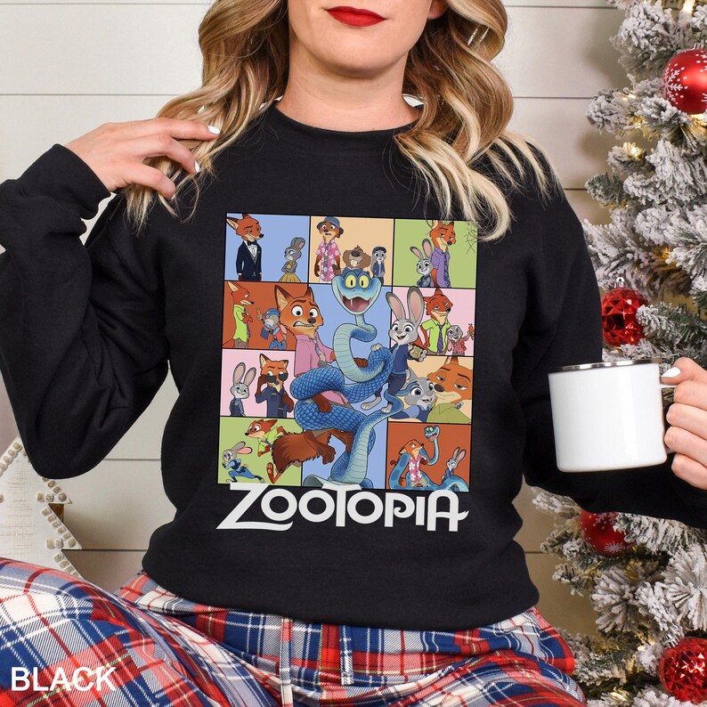 May include: Black crewneck sweatshirt featuring a colorful collage of characters from the animated film "Zootopia." The design includes the film's title in white block letters. The word "BLACK" is printed in white at the bottom left.