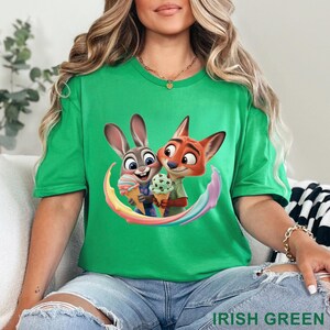 May include: Irish green t-shirt featuring a cartoon image of a rabbit and fox holding ice cream cones. The characters are surrounded by a rainbow arc. The text "IRISH GREEN" is printed at the bottom of the shirt.