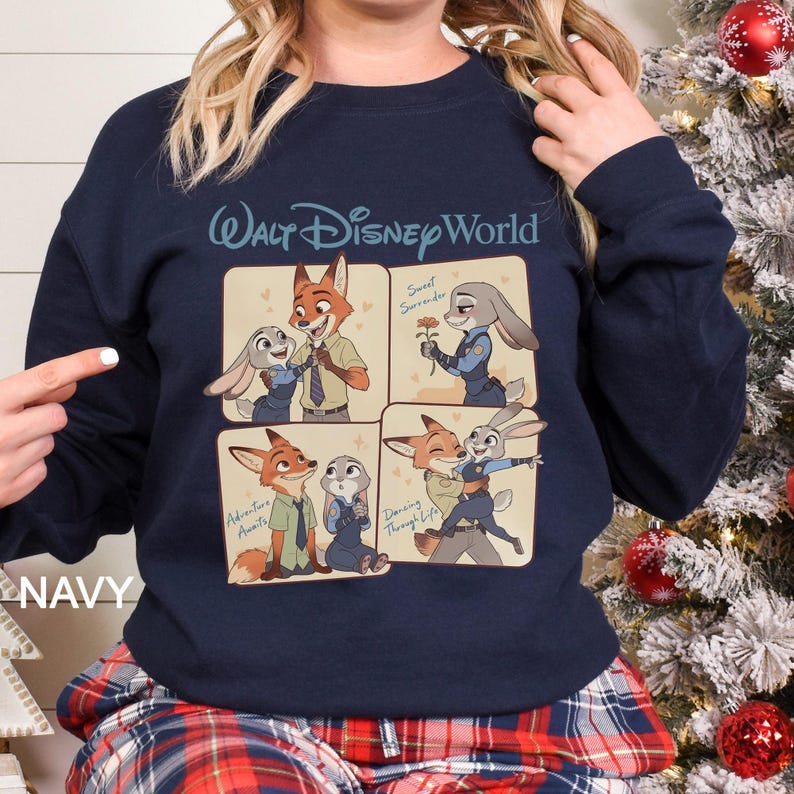 May include: Navy blue sweatshirt with a four-panel design featuring characters from the Disney film Zootropolis. The top panel has the text "Walt Disney World". Each panel depicts Nick Wilde and Judy Hopps. The word "NAVY" is printed on the bottom left.