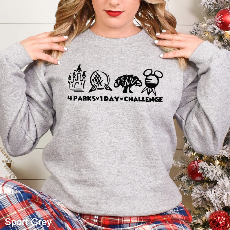 May include: A light gray sweatshirt with a black graphic that reads "4 Parks 1 Day Challenge" and features four iconic park symbols. The sweatshirt is a sport gray color.