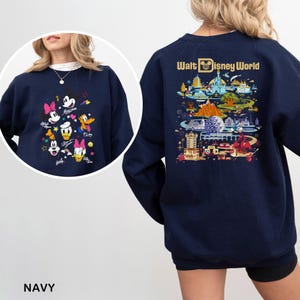May include: Navy blue sweatshirt featuring a colorful graphic of Disney characters on the front and a detailed illustration of Walt Disney World on the back. The sweatshirt includes the text "Walt Disney World".