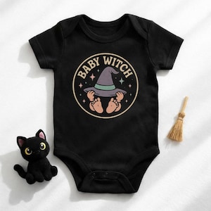 May include: Black baby bodysuit with a circular graphic reading "Baby Witch". The graphic shows a witch's hat, baby feet, and hands. A small black cat figurine and a miniature broom are next to the bodysuit.