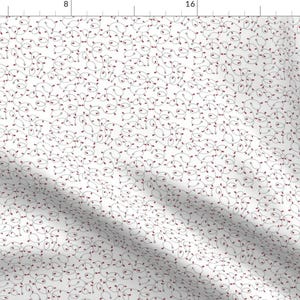 May include: White fabric with a repeating pattern of red and black Christmas lights. The lights are arranged in a random pattern and are connected by thin black lines.