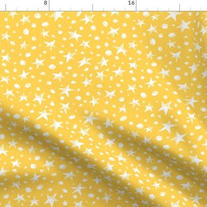 May include: A yellow fabric with a white star and circle pattern.