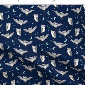以下が含まれることがあります： 紺色の生地に、白い星と三日月を背景に、羽を広げて飛んでいる灰色のフクロウが繰り返し描かれたパターンがあります。