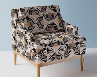 May include: A cream-coloured armchair with a black, gold, and pink geometric pattern. The chair has a high back and wooden legs.