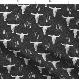 May include: Dark grey fabric featuring a repeating pattern of white steer skulls and arrow motifs. The fabric has a textured appearance. The design is a monochrome, rustic style.