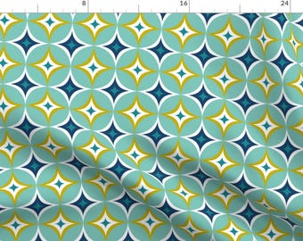May include: A repeating pattern of teal, navy blue, white, and gold geometric shapes. The pattern features overlapping circles and four-pointed stars.