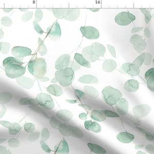 Op de afbeelding: Een naadloos patroon met aquarel illustraties van eucalyptusbladeren in tinten groen op een witte achtergrond.