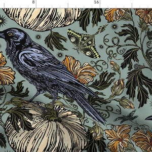 Può includere: Un corvo blu e nero appollaiato su una zucca bianca con un motivo floreale verde, arancione e nero su uno sfondo blu chiaro.