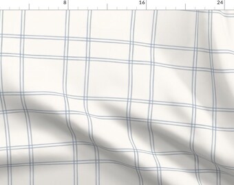 Può includere: Tessuto bianco con un motivo a quadri bianco e blu chiaro. Il tessuto è piegato e presenta una leggera piega.