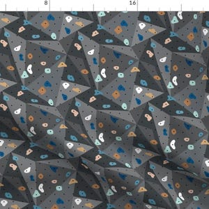 May include: A seamless pattern featuring a climbing wall with various colored holds. The wall is gray with black dots and the holds are in shades of blue, brown, white, and pink.