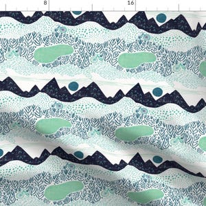 May include: A white fabric with a repeating pattern of blue and green mountains, ponds, and flowers. The pattern is whimsical and organic.