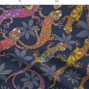 May include: A fabric pattern featuring colorful, stylized geckos and flowers on a dark blue background. The geckos are decorated with intricate patterns in shades of orange, pink, yellow, and green. The flowers are gray.