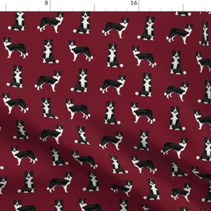 May include: A repeating pattern of black and white border collies on a burgundy background. The dogs are all facing forward and have their tongues sticking out.
