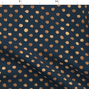 May include: A navy blue fabric with a repeating pattern of tan polka dots. The dots are slightly irregular in shape and size, giving the fabric a hand-painted look.