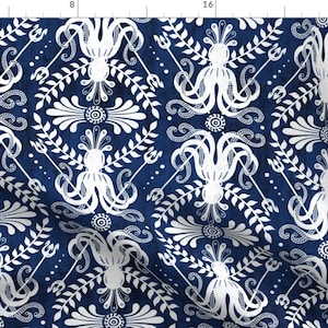 Op de afbeelding: Een marineblauwe stof met een wit, herhalend patroon van gestileerde octopussen, drietanden en bloemmotieven.