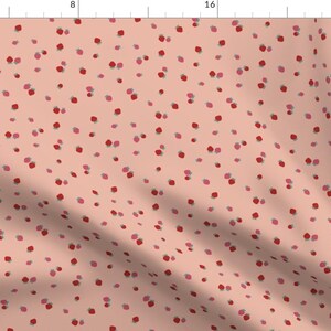 May include: A seamless pattern featuring a repeating design of small, red and pink flowers on a light peach background.