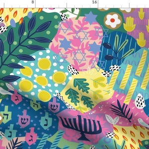 Może przedstawiać: Kolorowy wzór tkaniny patchworkowej z różnymi symbolami żydowskimi, w tym Gwiazdą Dawida, menorą, drejdlem i ręką Hamsy. Tkanina idealnie nadaje się do tworzenia świątecznych ozdób i dekoracji na Chanukę.