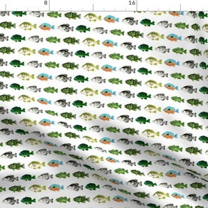 May include: A white fabric with a repeating pattern of colorful fish. The fish are in various shades of green, blue, orange, and black. The fish are all facing the same direction and are arranged in rows.