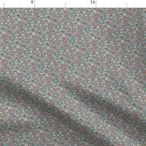 May include: A gray fabric with a repeating pattern of colorful, small, cartoon-like images. The images include a variety of shapes and designs, such as stars, hearts, and geometric shapes.