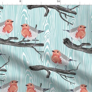 May include: A seamless pattern featuring stylized robins perched on bare branches against a blue and white woodgrain background.