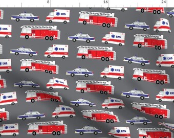 May include: A gray fabric featuring a repeating pattern of emergency vehicles. The design includes red fire trucks, white ambulances with "EMS" text, and blue and white police cars. The vehicles are scattered across the fabric.