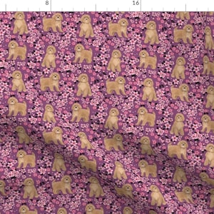 Puede incluir: Un patrón sin costuras que presenta un perro doodle dorado de pie en un campo de flores de cerezo rosas sobre un fondo morado.