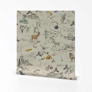 May include: Wallpaper roll featuring a detailed black and white mountain scene with a beige background. The design includes illustrations of cabins, animals, trees, and recreational activities like skiing, biking, and paragliding.