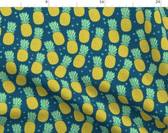 May include: A repeating pattern of yellow pineapples with green tops and small blue dots on a dark teal background. The pineapples are evenly spaced and create a tropical, summery design.