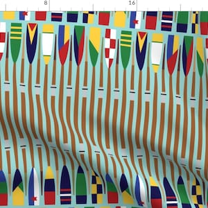 Peut inclure: Un motif répété de rames brunes avec des drapeaux colorés en haut. Les rames sont disposées en motif vertical sur un fond bleu clair.