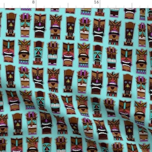 May include: A repeating pattern of colorful tiki mask faces on a light blue background. The masks are brown, orange, pink, blue, and green.