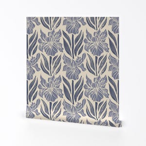 Könnte beinhalten: Eine Tapetenrolle mit einem sich wiederholenden Muster aus blauen Irisblüten und Blättern auf cremefarbenem Hintergrund. Das florale Design hat eine Vintage- und botanische Ästhetik mit einem strukturierten, gedruckten Aussehen.
