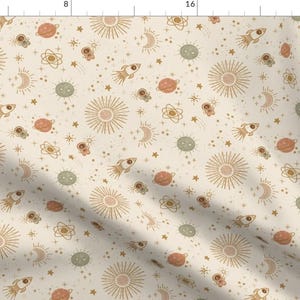 Pode incluir: Um padrão sem costura com um tema espacial caprichoso com estrelas, planetas, sóis, luas e foguetes em tons dourados, marrons e verdes sobre um fundo creme.