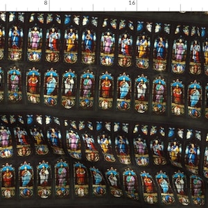 Peut inclure: Un motif répété de vitraux représentant des personnages colorés dans différentes poses. Les vitraux sont sur un fond sombre.